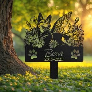 Personalized Australian Cattle Dog metal pet grave marker with angel wings and daisy flowers, displayed in a sunlit garden with color swatch options