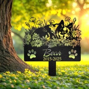 Personalized Australian Cattle Dog metal pet grave marker in a sleeping pose surrounded by daisy flowers, displayed in a sunlit garden with color swatch options