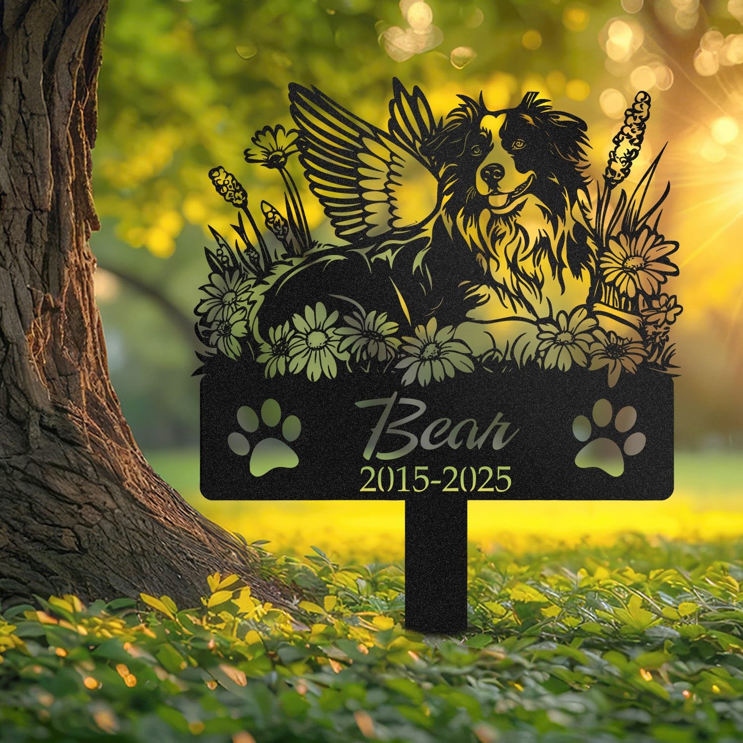 Australian Shepherd curled angel wings pet grave marker shown close up in a sunlit garden with daisy flowers and grass