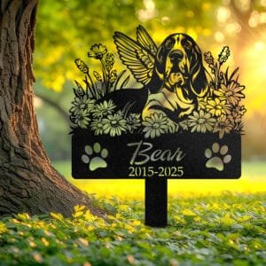 Personalized Basset Hound metal pet grave marker with angel wings and daisy flowers, displayed in a sunlit garden with color swatch options