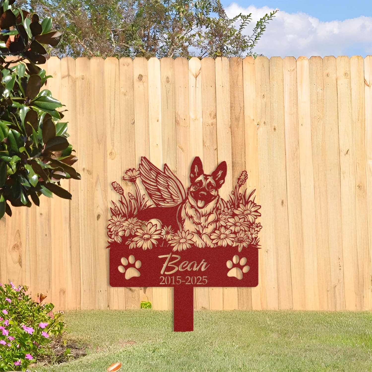 Belgian Malinois pet grave marker in a maroon powder-coat finish displayed against a wooden fence backdrop with greenery