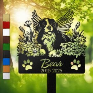 Personalized Bernese Mountain Dog metal pet grave marker with angel wings and daisy flowers, displayed in a sunlit garden with color swatch options