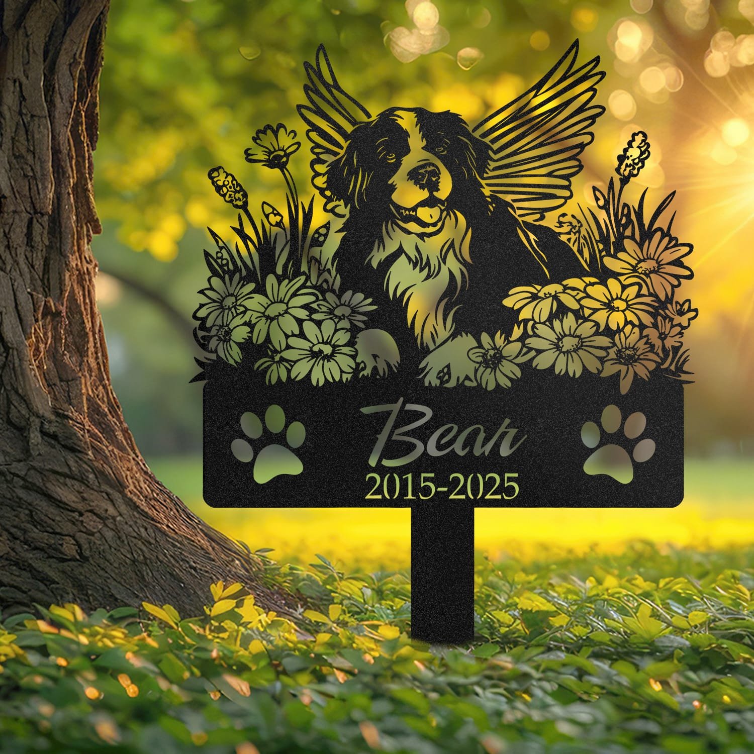 Bernese Mountain Dog angel wings pet grave marker staked into the ground beside a large tree trunk in a garden setting