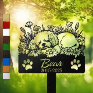 Personalized Bichon Frise metal pet grave marker in a sleeping pose surrounded by daisy flowers, displayed in a sunlit garden with color swatch options