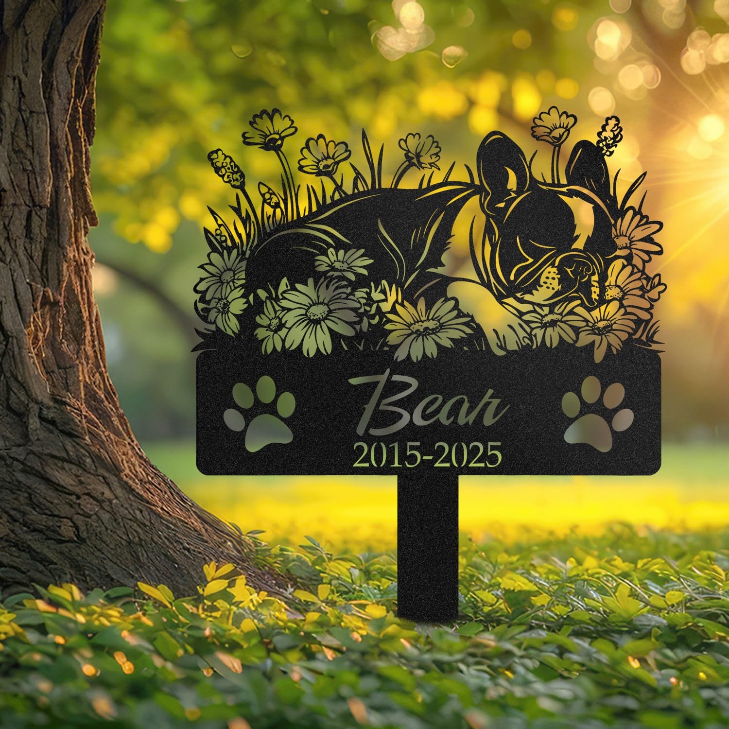 Boston Terrier sleeping pose pet grave marker staked into the ground beside a large tree trunk in a garden setting