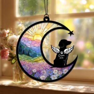 Crescent moon suncatcher with an angel-winged Dachshund silhouette in side profile over a stained-glass daisy field