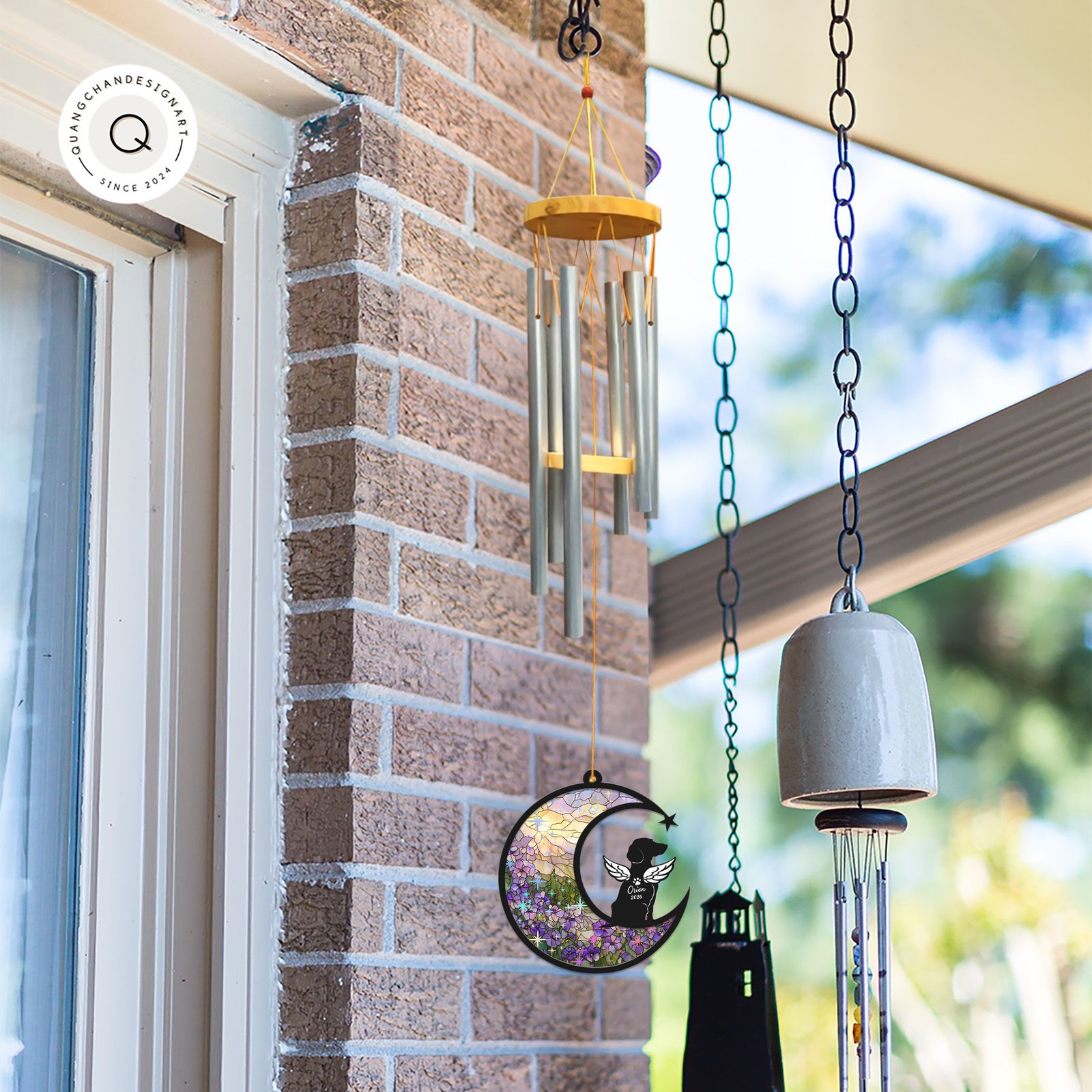 Wind chime with a Dachshund memorial suncatcher hanging outdoors near a window alongside other garden bells and chimes