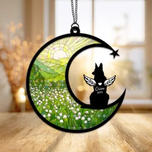 Crescent moon suncatcher with an alert angel-winged German Shepherd silhouette beside a shooting star over a green lily of the valley field