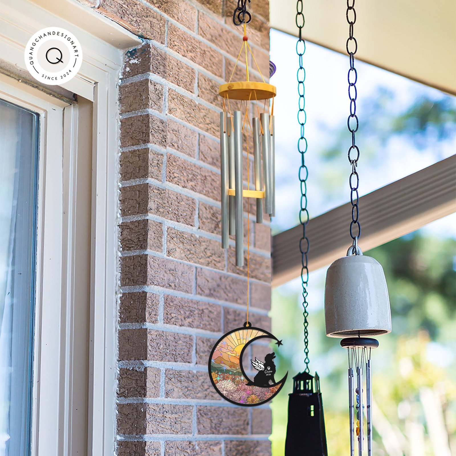 Wind chime with a Golden Retriever memorial suncatcher hanging outdoors near a brick wall alongside other garden bells and chimes