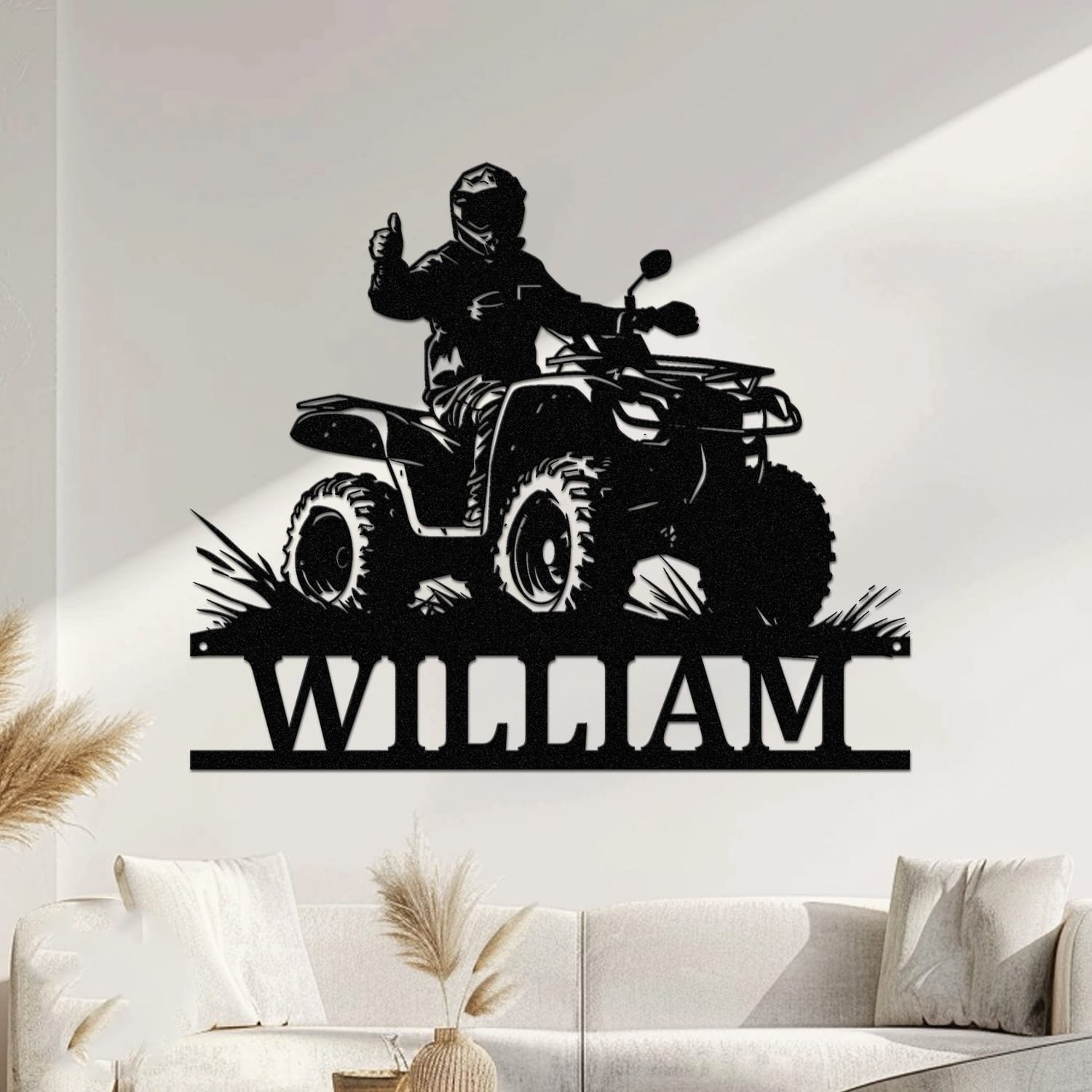 Rider giving a thumbs-up atop an ATV riding through brush, with a custom name cut into the base of a personalized metal wall sign.