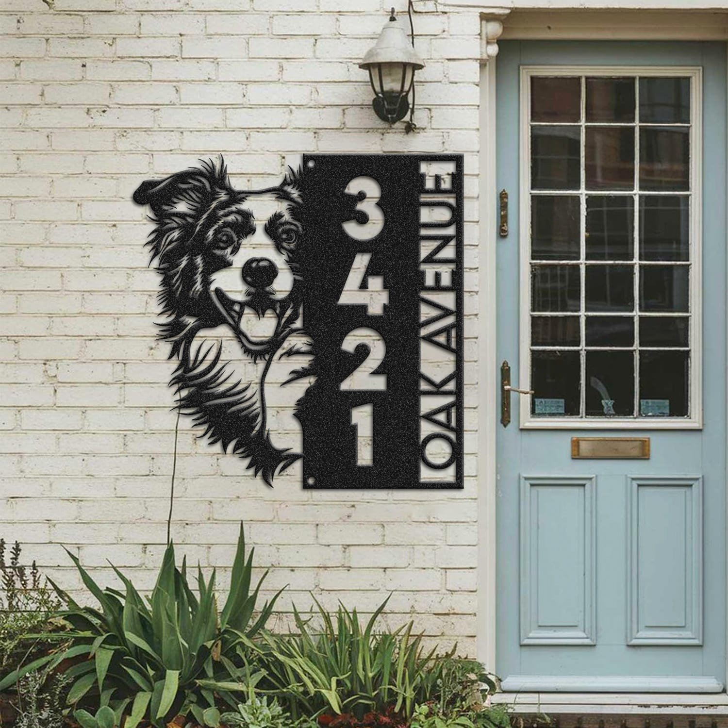 Border Collie address sign mounted on a painted brick wall beside a wooden front door
