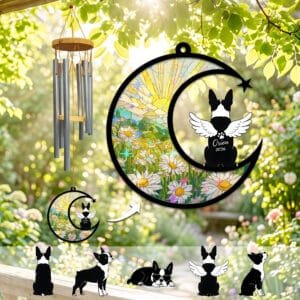 Stained-glass memorial wind chime suncatcher showing a Boston Terrier silhouette with angel wings sitting on a crescent moon over a daisy meadow at sunrise
