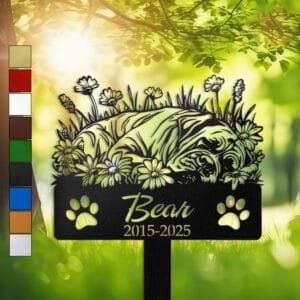 Personalized Cane Corso metal pet grave marker in a sleeping pose surrounded by daisy flowers, displayed in a sunlit garden with color swatch options