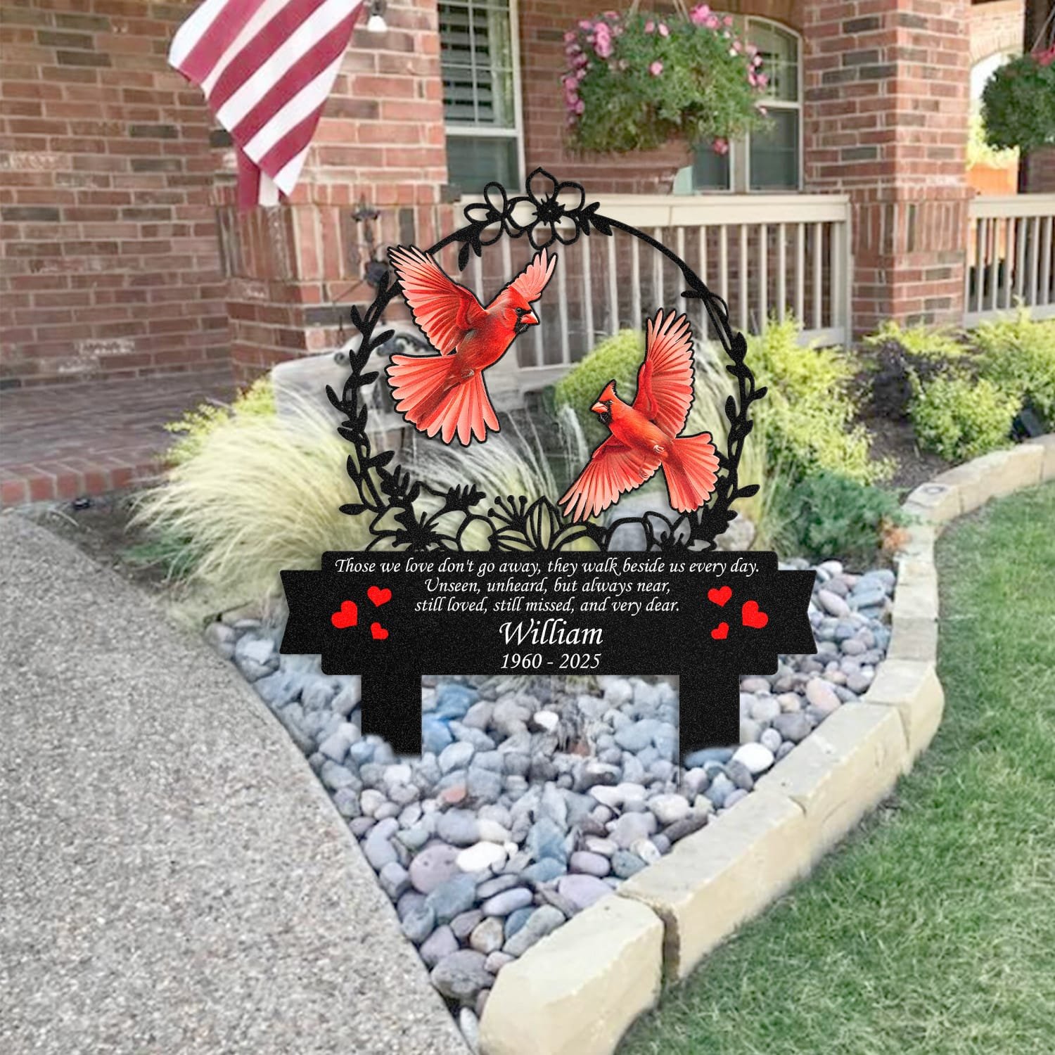 Cardinal human grave marker staged near a home entryway, showing the finished floral wreath bird-pair design and memorial verse outdoors.