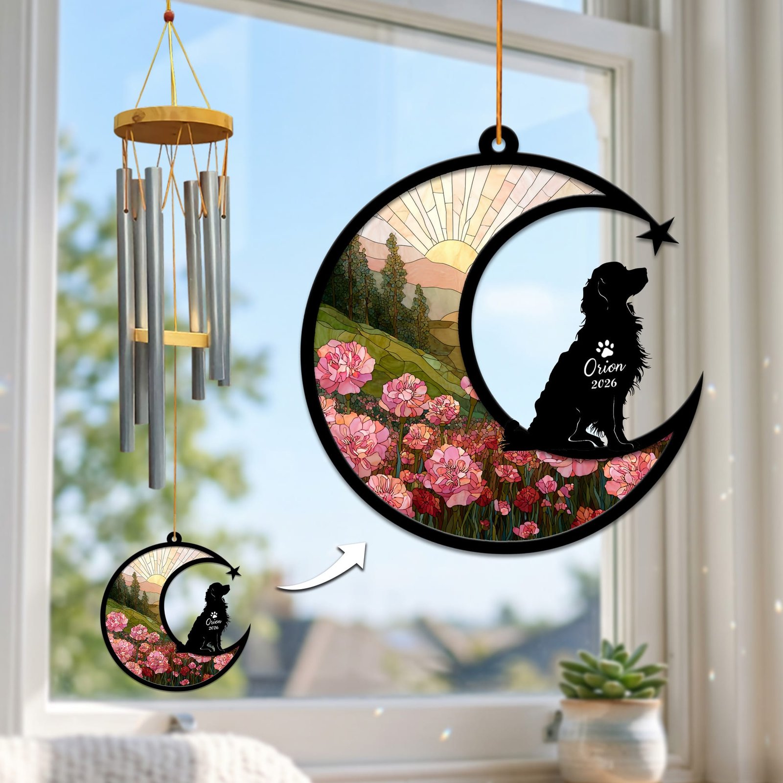 Stained-glass memorial wind chime suncatcher showing a Cavalier King Charles Spaniel silhouette looking up from a crescent moon over pink carnations, hanging in a sunny window