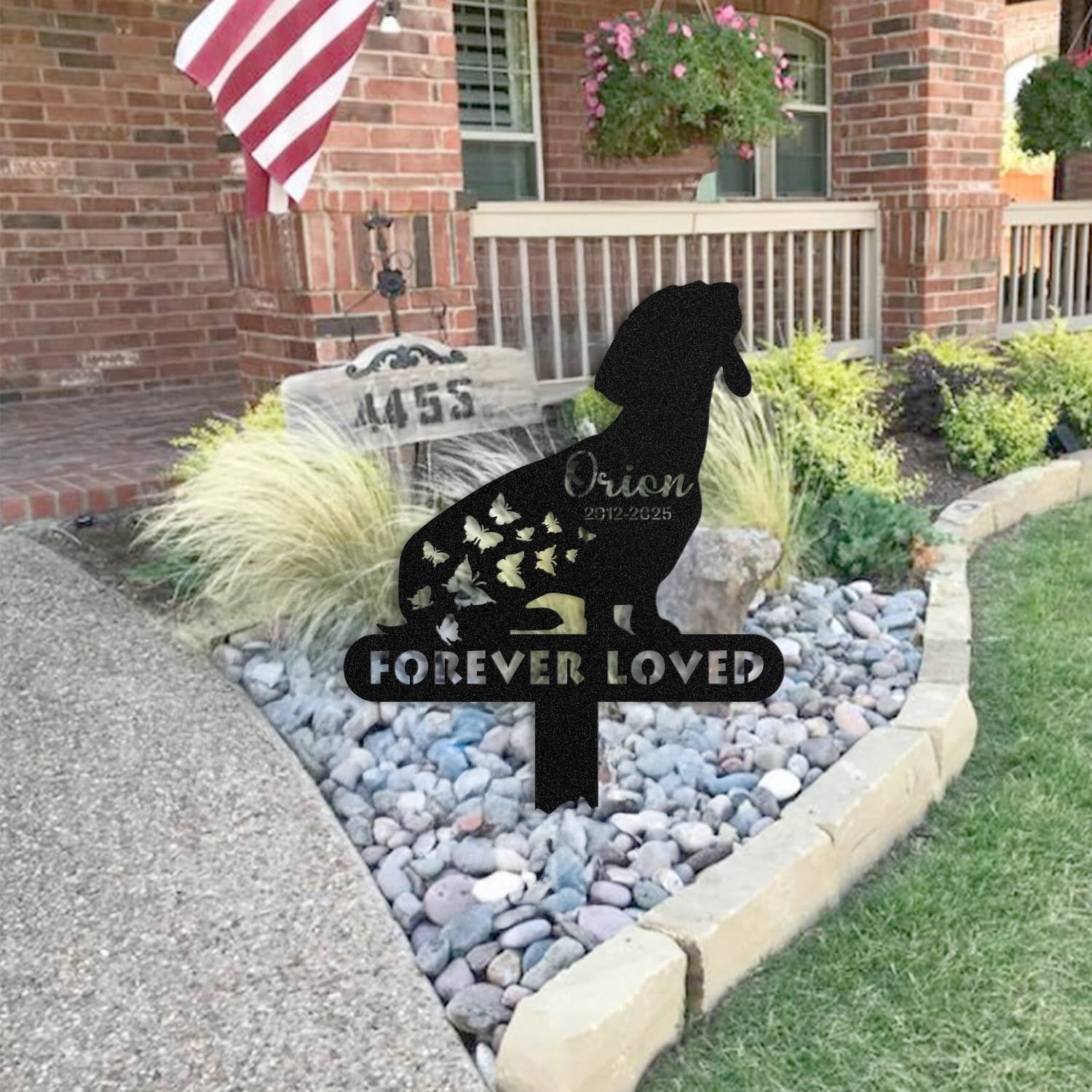Dachshund pet grave marker staged near a home entryway, showing the finished butterfly silhouette design with the 'Forever Loved' engraving and name plate outdoors.