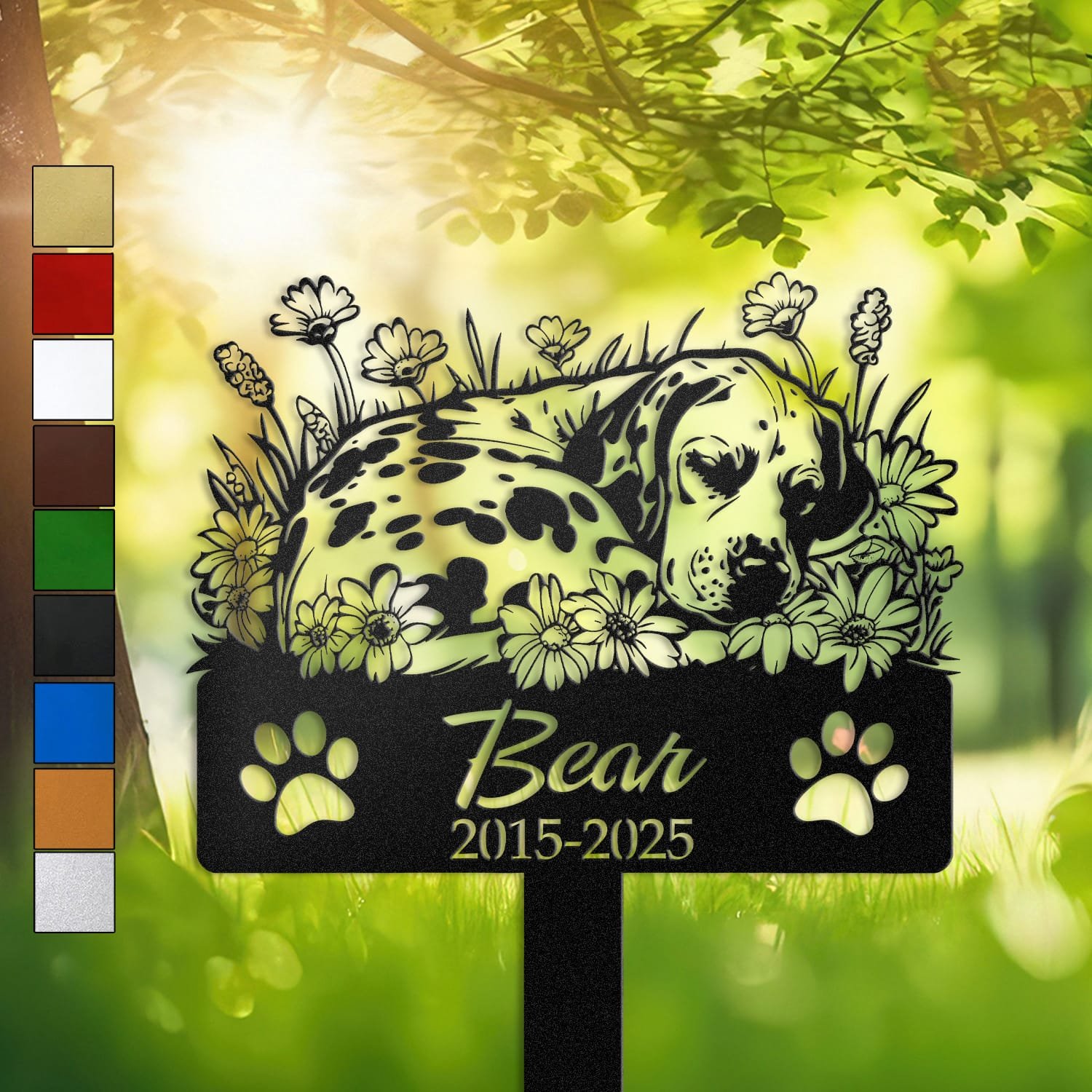 Dalmatian sleeping pose pet grave marker staked into the ground beside a large tree trunk in a garden setting