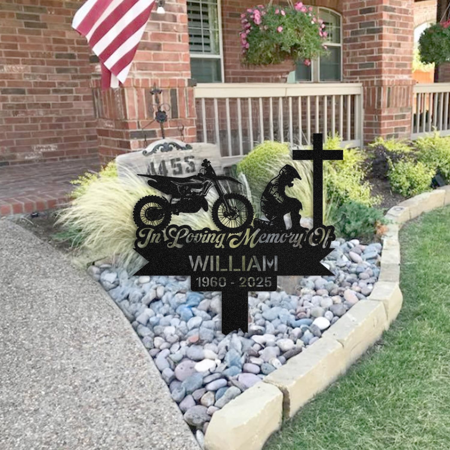 Dirt Bike human grave marker staged near a home entryway, showing the finished dirt bike kneeling-at-the-cross design and name plate outdoors.