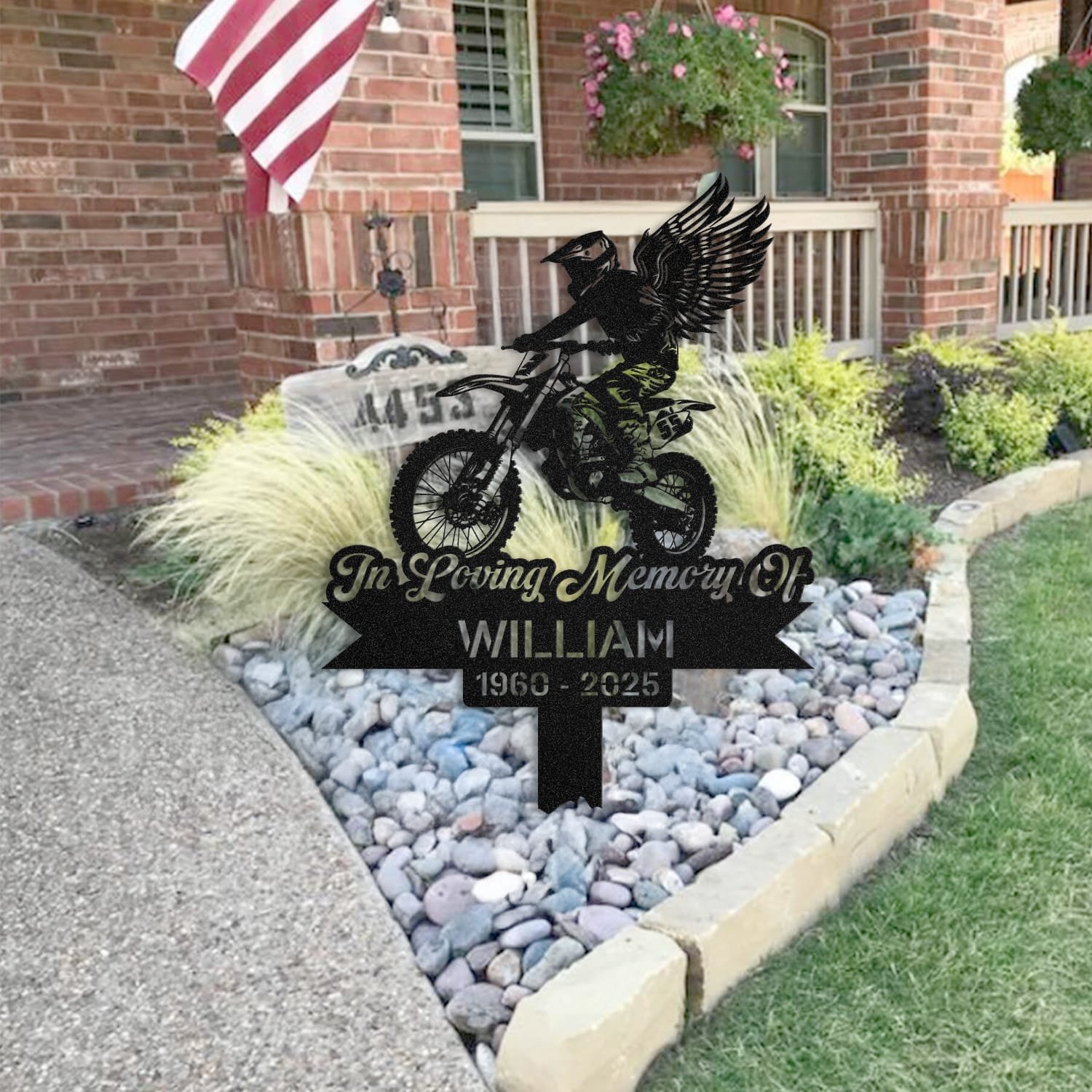 Dirt Bike human grave marker staged near a home entryway, showing the finished dirt bike winged rider design and name plate outdoors.