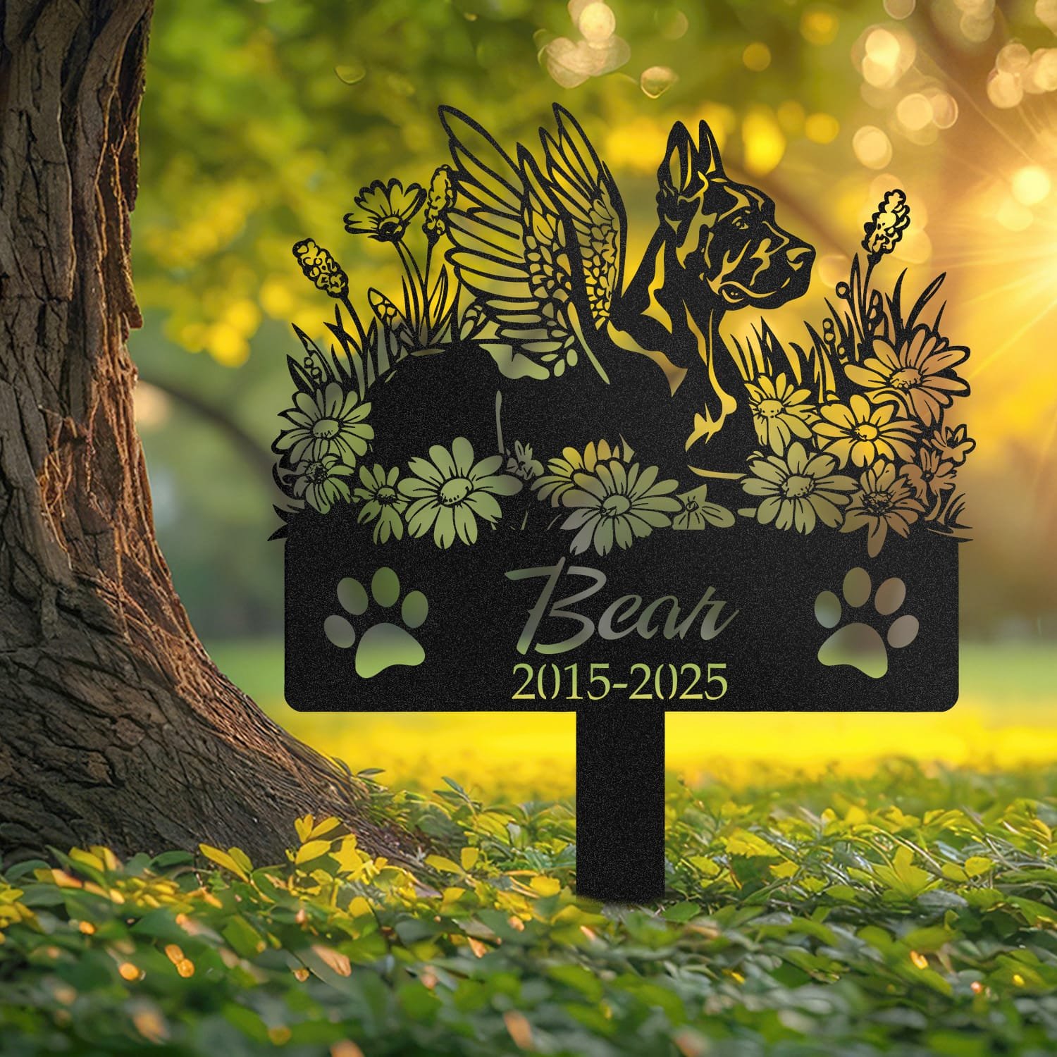 Doberman angel wings pet grave marker staked into the ground beside a large tree trunk in a garden setting