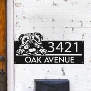 Personalized English Bulldog address sign attached flush to a brick wall beside a blue front door, reading 3421 Oak Avenue