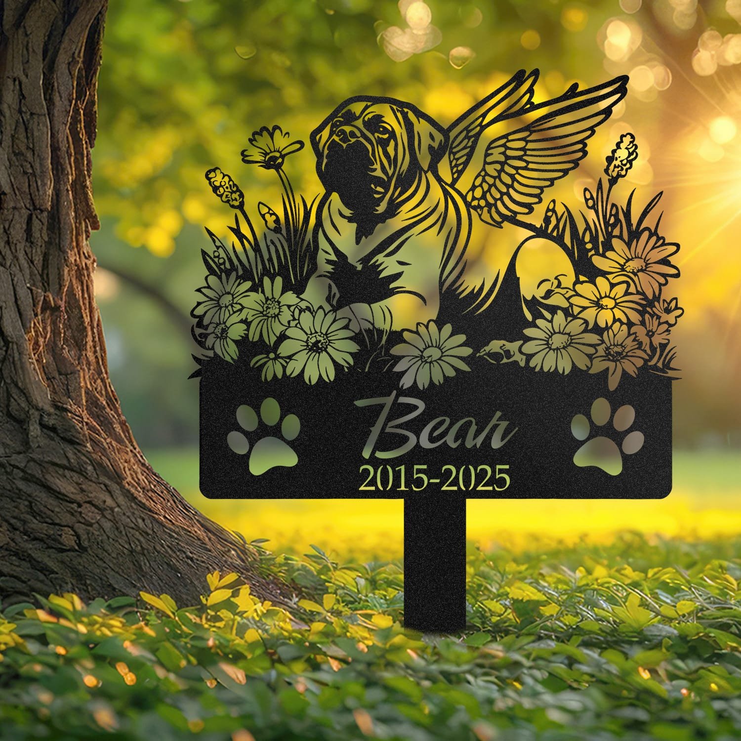 English Mastiff angel wings pet grave marker staked into the ground beside a large tree trunk in a garden setting