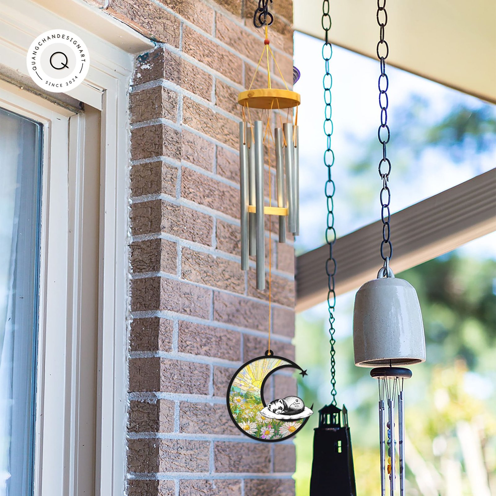 Ferret wind chime suncatcher hanging beside a brick wall and window next to other decorative bells and chimes