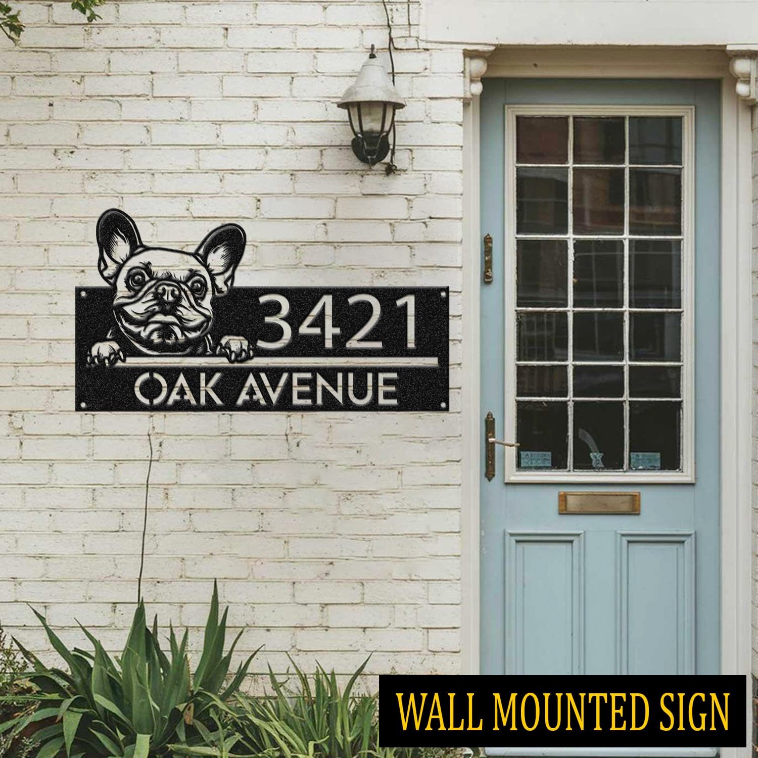 Personalized French Bulldog address sign attached flush to a brick wall beside a blue front door, reading 3421 Oak Avenue