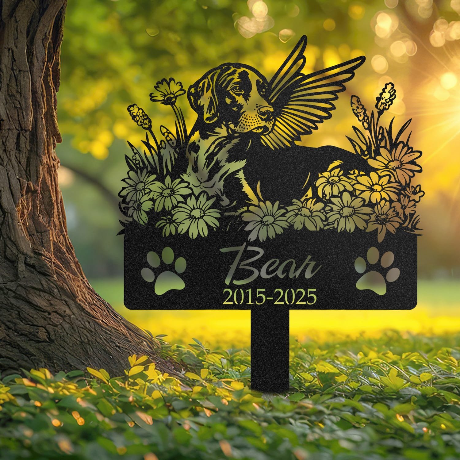 German Shorthaired Pointer angel wings pet grave marker staked into the ground beside a large tree trunk in a garden setting