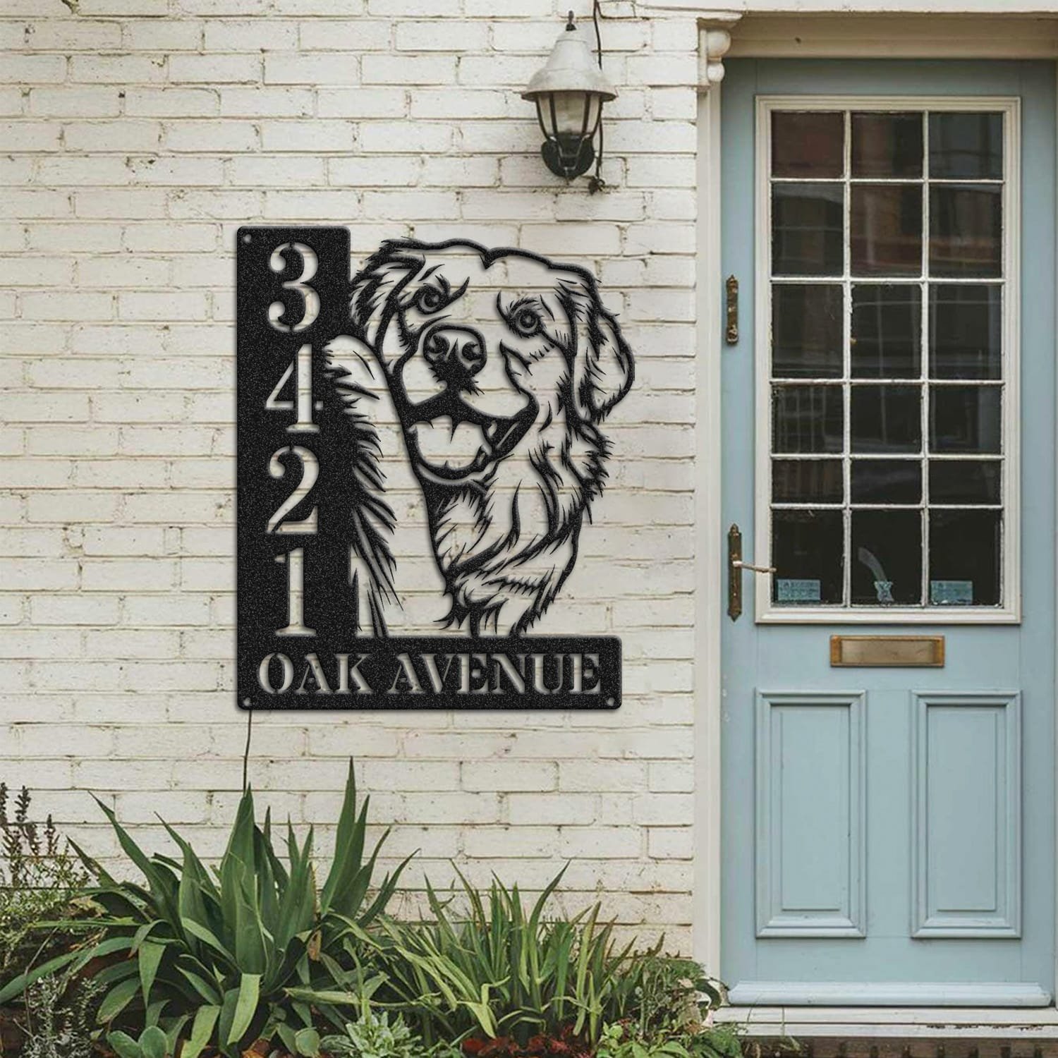 Golden Retriever address sign mounted on a painted brick wall beside a wooden front door