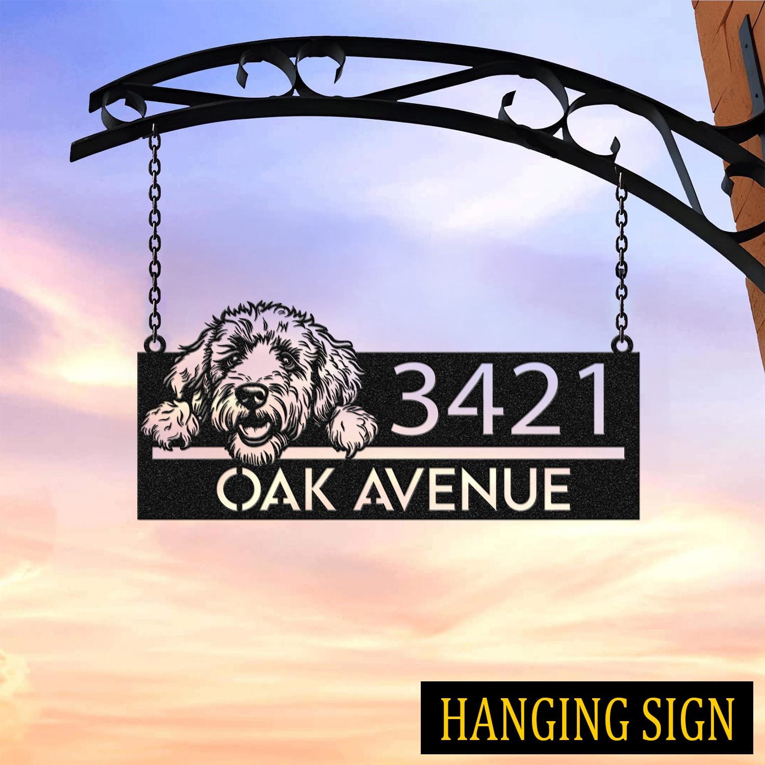 Goldendoodle address sign hanging by chains from a wrought iron bracket against a sunset sky