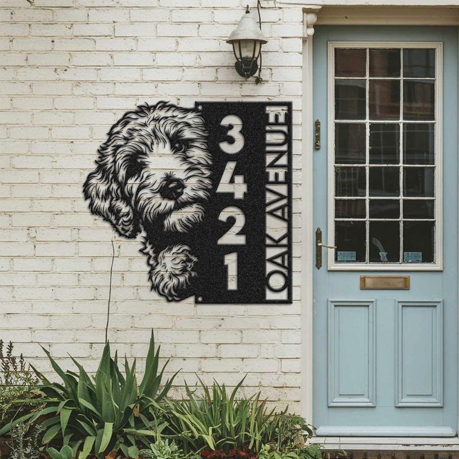 Goldendoodle address sign mounted on a painted brick wall beside a wooden front door