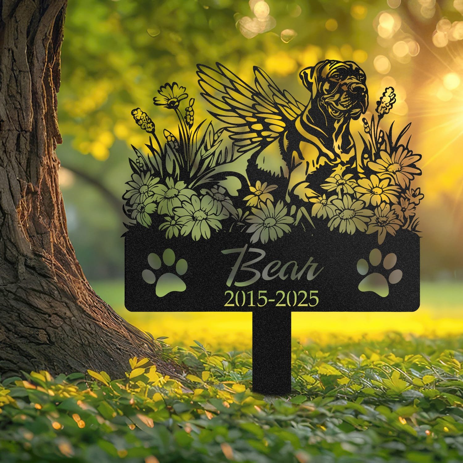 Great Dane angel wings pet grave marker staked into the ground beside a large tree trunk in a garden setting