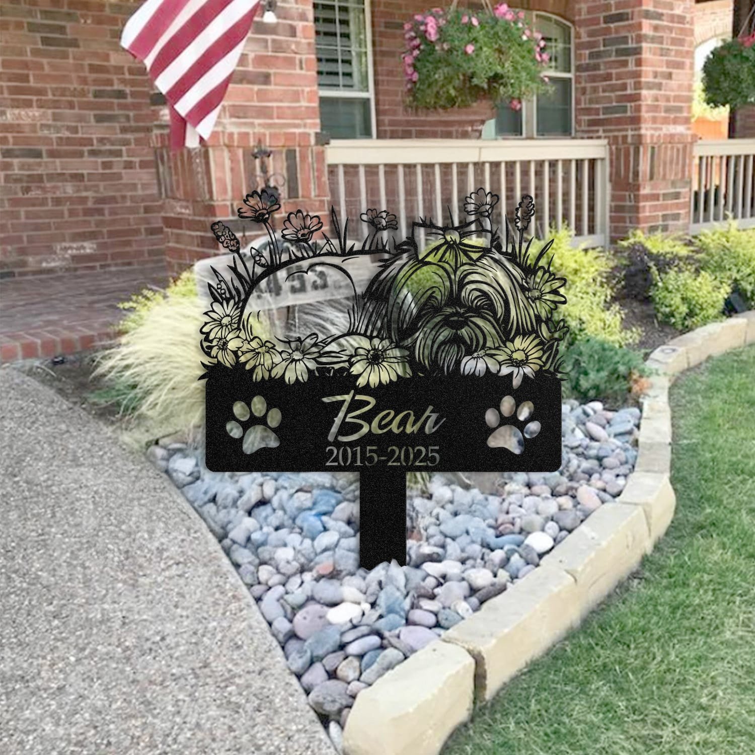 Long Hair Shih Tzu pet grave marker staged near a home entryway, showing the finished sleeping-pose daisy floral design and name plate outdoors.