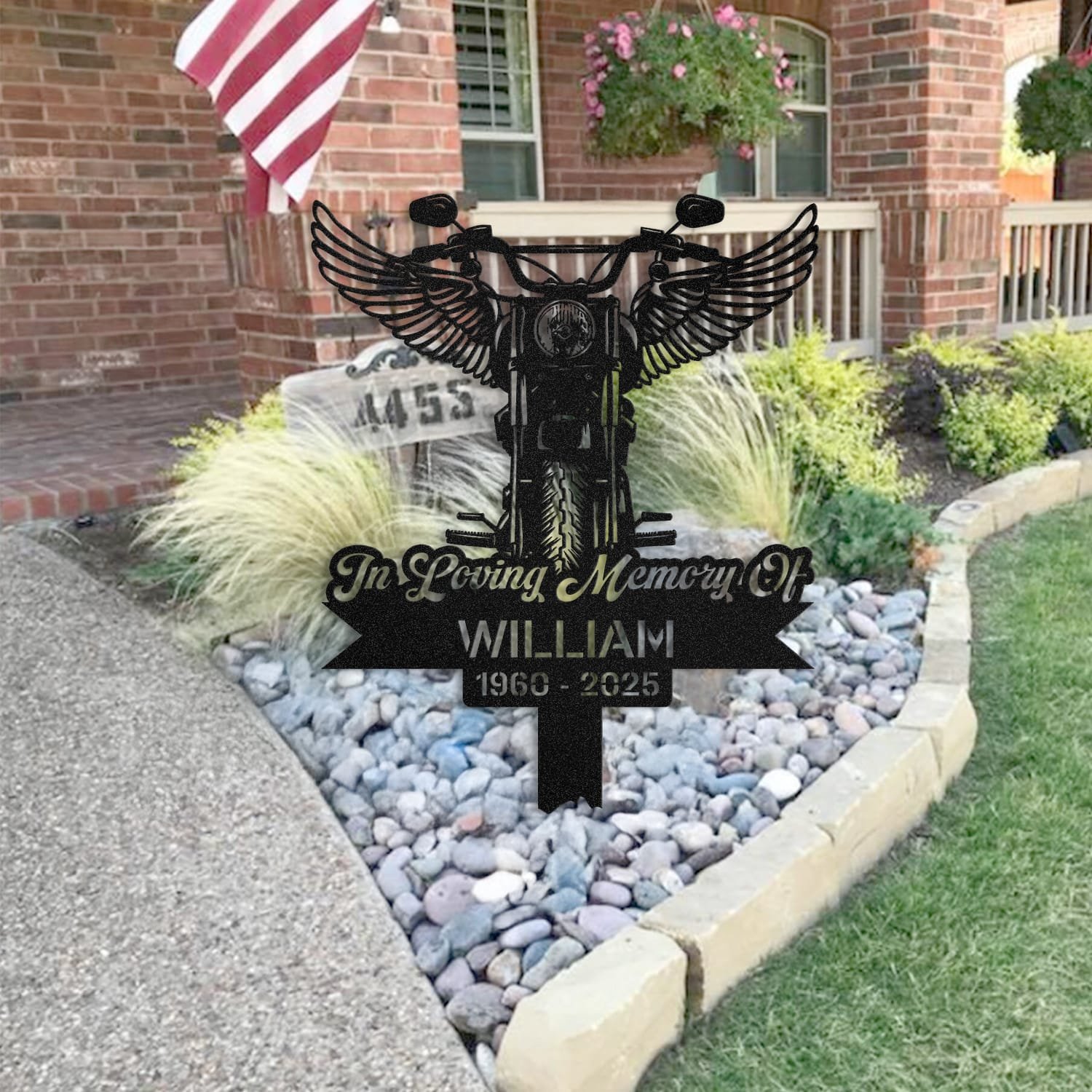 Motorcycle human grave marker staged near a home entryway, showing the finished motorcycle angel wings design and name plate outdoors.