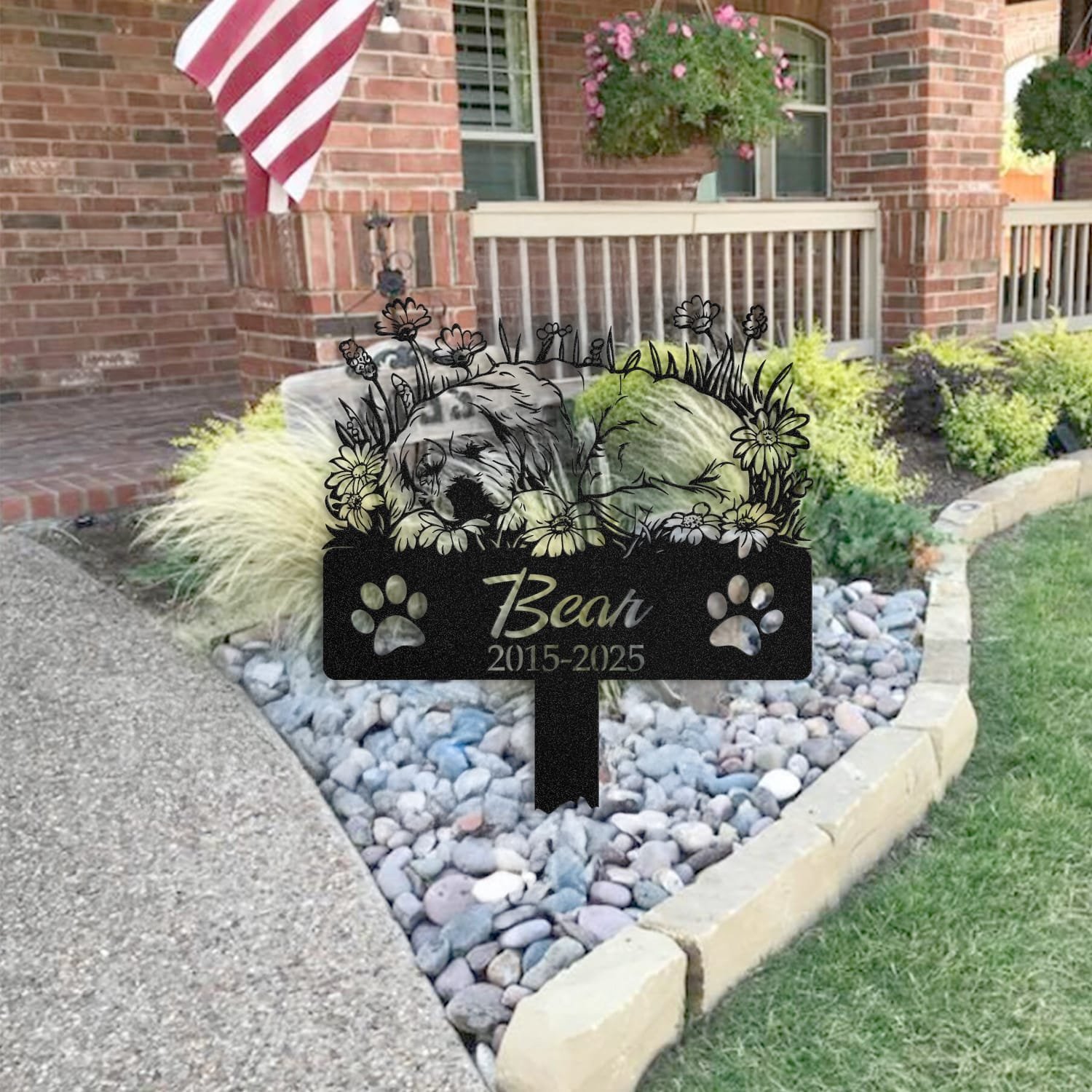Newfoundland pet grave marker staged near a home entryway, showing the finished sleeping-pose daisy floral design and name plate outdoors.