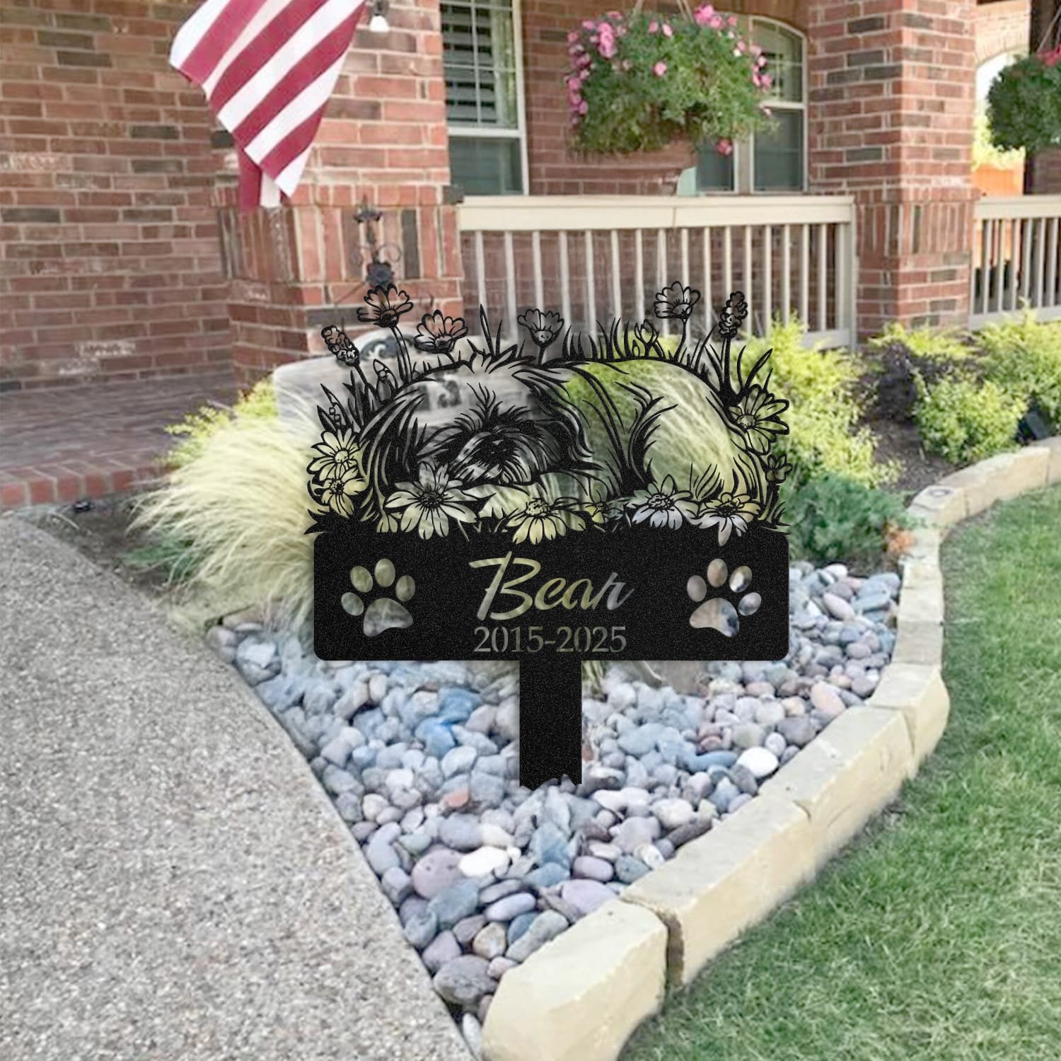 Pekingese pet grave marker staged near a home entryway, showing the finished sleeping-pose daisy floral design and name plate outdoors.