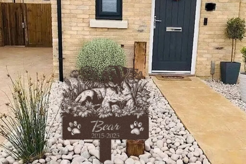 Pet memorial garden marker in a stone garden bed, an example of a year-round pet memorial garden layout