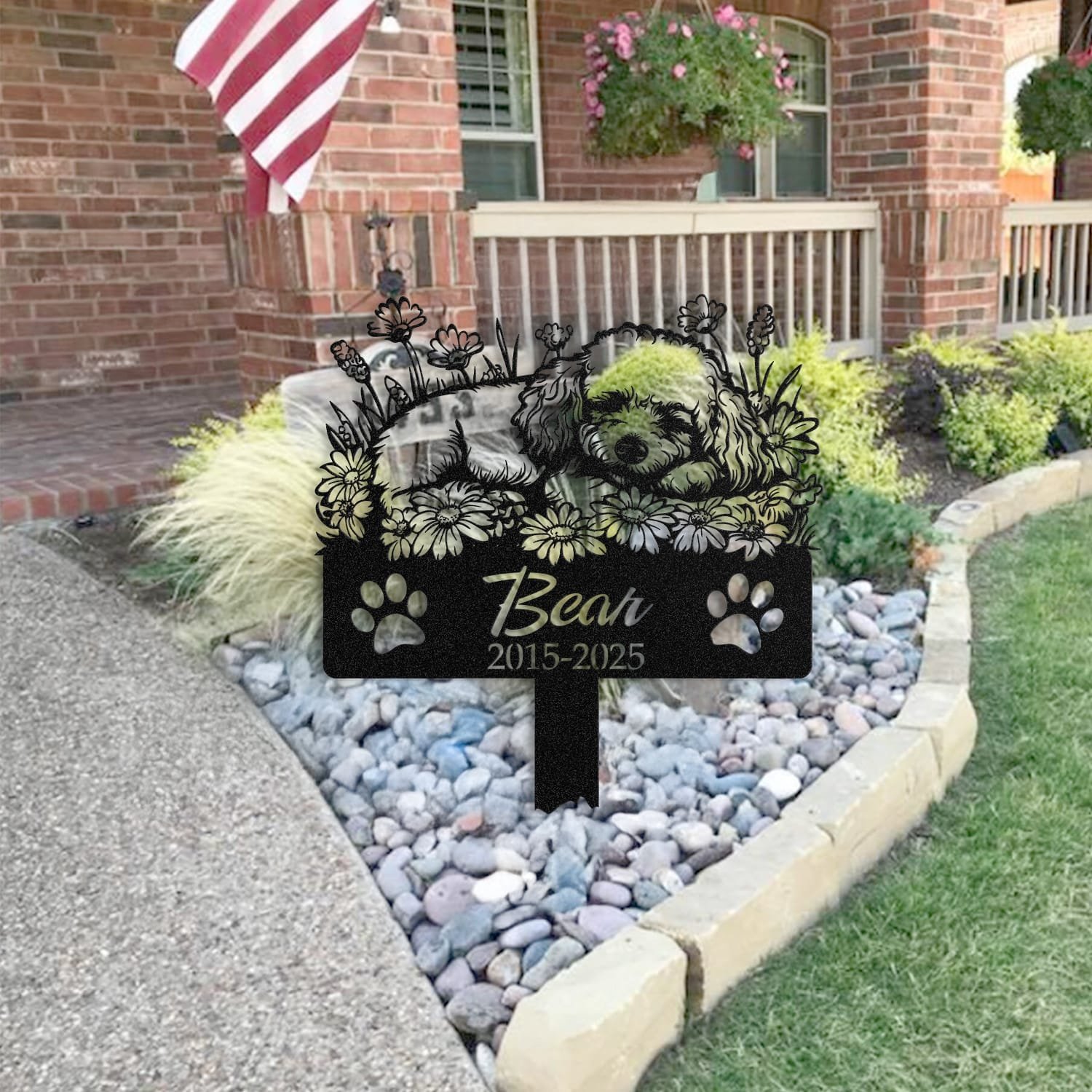 Poodle pet grave marker staged near a home entryway, showing the finished sleeping-pose daisy floral design and name plate outdoors.