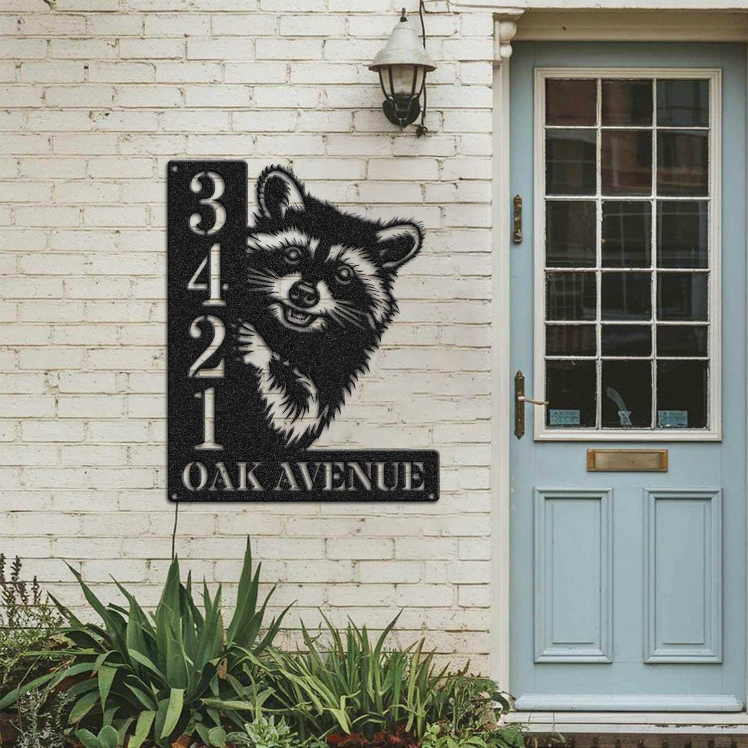 Raccoon address sign mounted on a painted brick wall beside a wooden front door