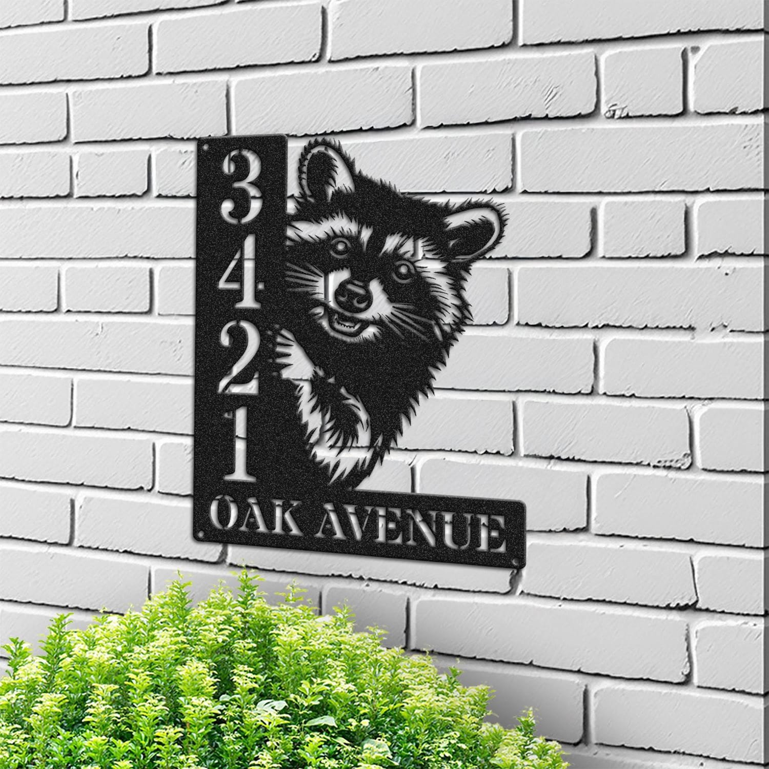 Raccoon address sign mounted on a light brick wall in a street-facing view