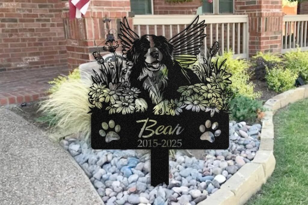 Pet memorial garden marker in a rock garden bed, tended as part of an anniversary remembrance ritual