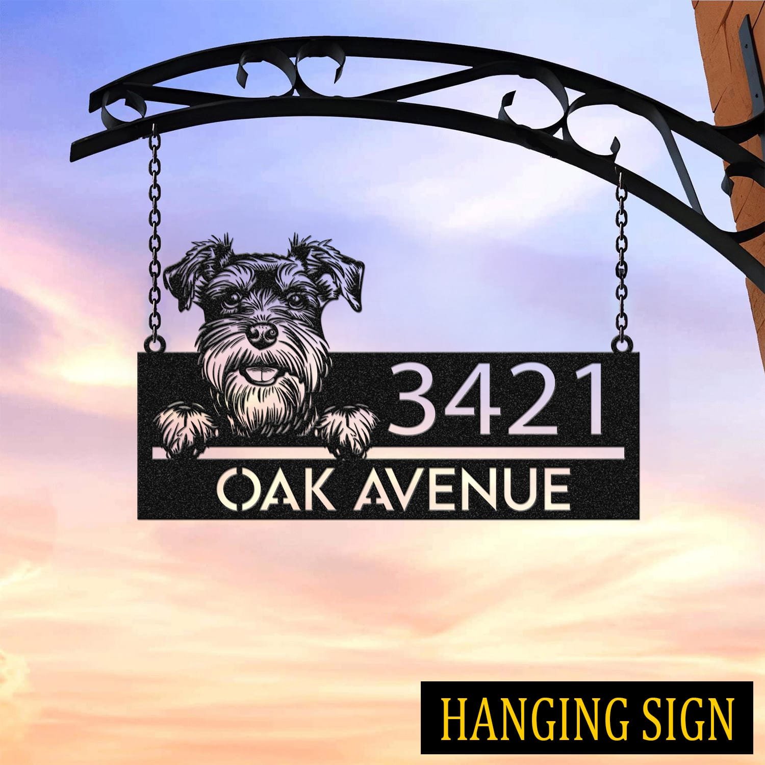 Schnauzer address sign hanging by chains from a wrought iron bracket against a sunset sky