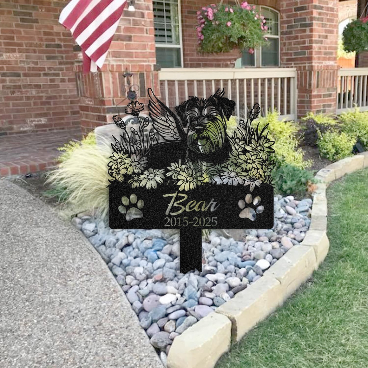 Schnauzer pet grave marker staged near a home entryway, showing the finished sleeping-pose daisy floral design and name plate outdoors.