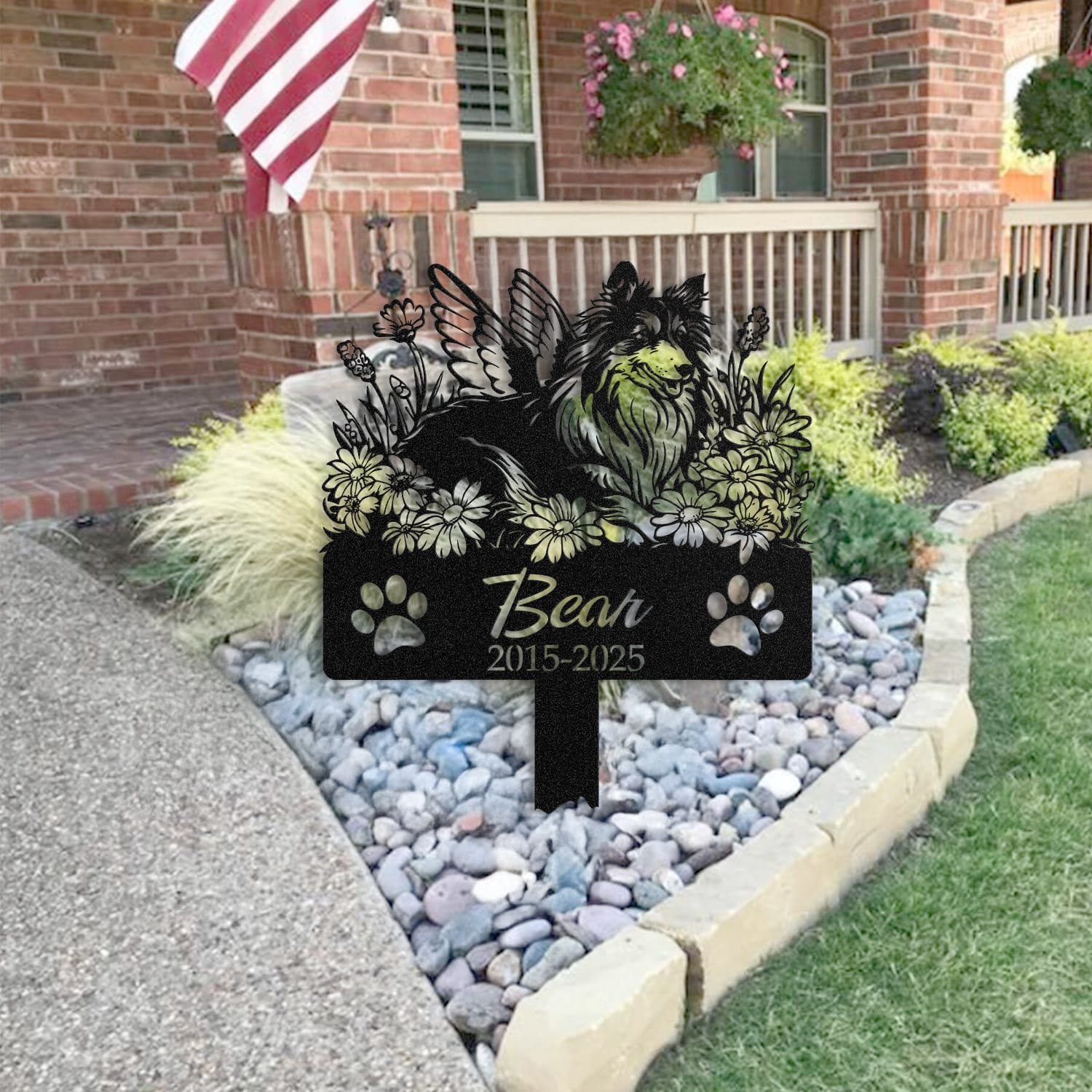 Shetland Sheepdog pet grave marker staged near a home entryway, showing the finished angel wings and daisy floral design and name plate outdoors.