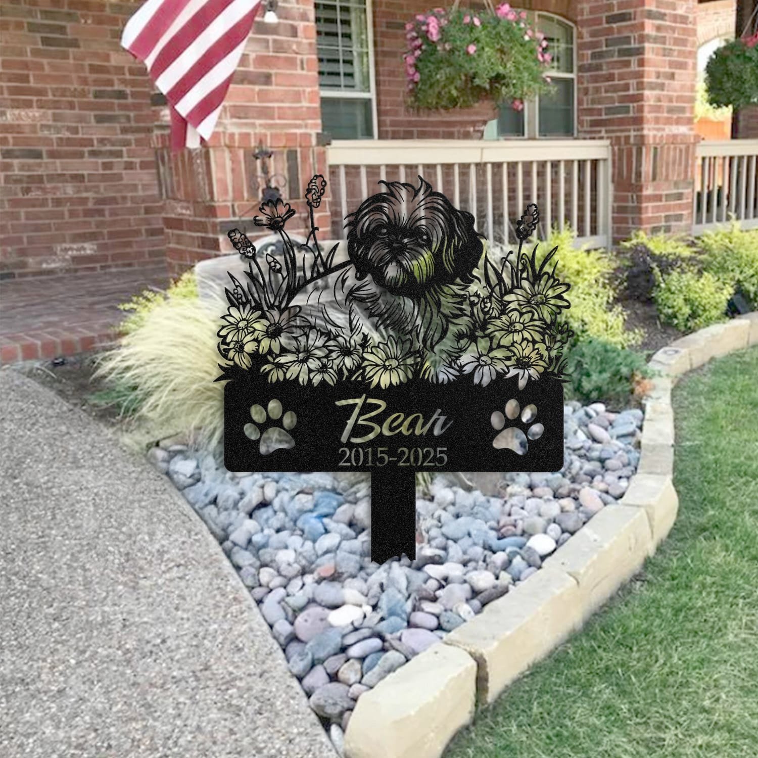Shih Tzu pet grave marker staged near a home entryway, showing the finished sleeping-pose daisy floral design and name plate outdoors.