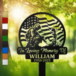 Metal memorial design of a soldier kneeling beside a battlefield cross of boots, helmet, and rifle, framed by a waving American flag, set within a circular medallion frame and engraved with 'In Loving Memory Of', personalized with a name and memorial years.
