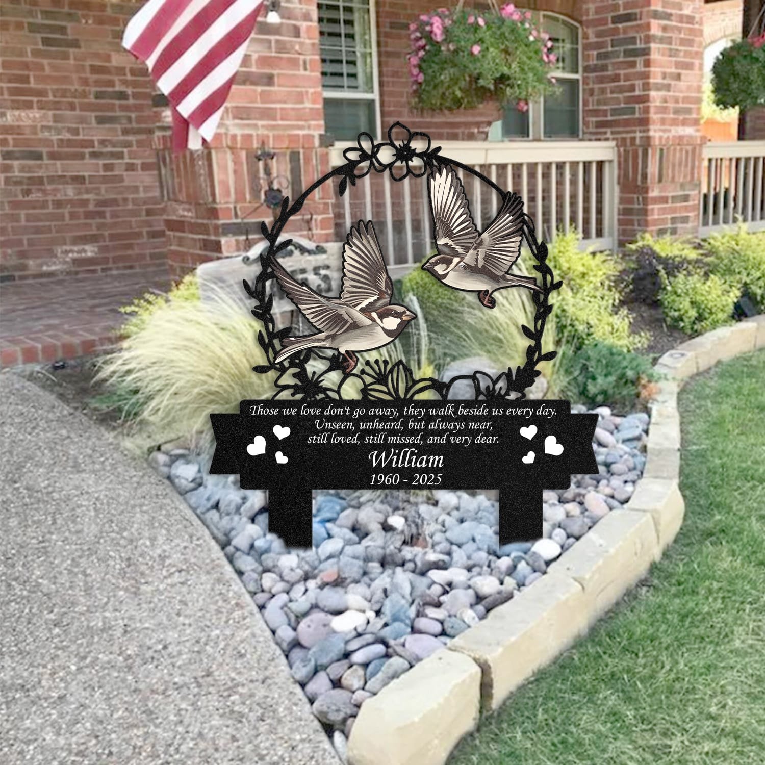 Sparrow human grave marker staged near a home entryway, showing the finished floral wreath bird-pair design and memorial verse outdoors.