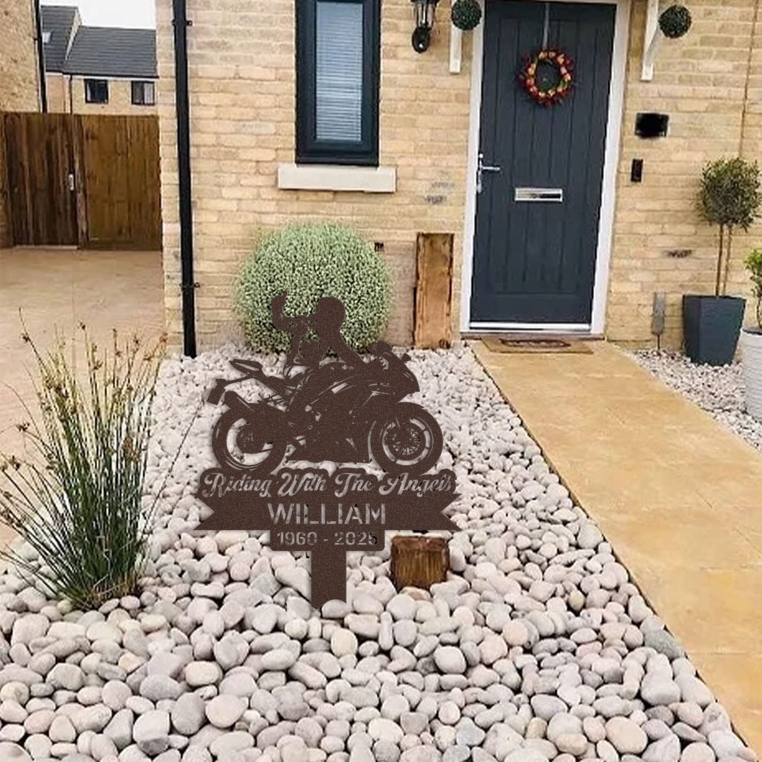 Sport Motorcycle human grave marker displayed among garden plants and stone edging, showing the sport motorcycle rider silhouette design as an outdoor memorial accent.