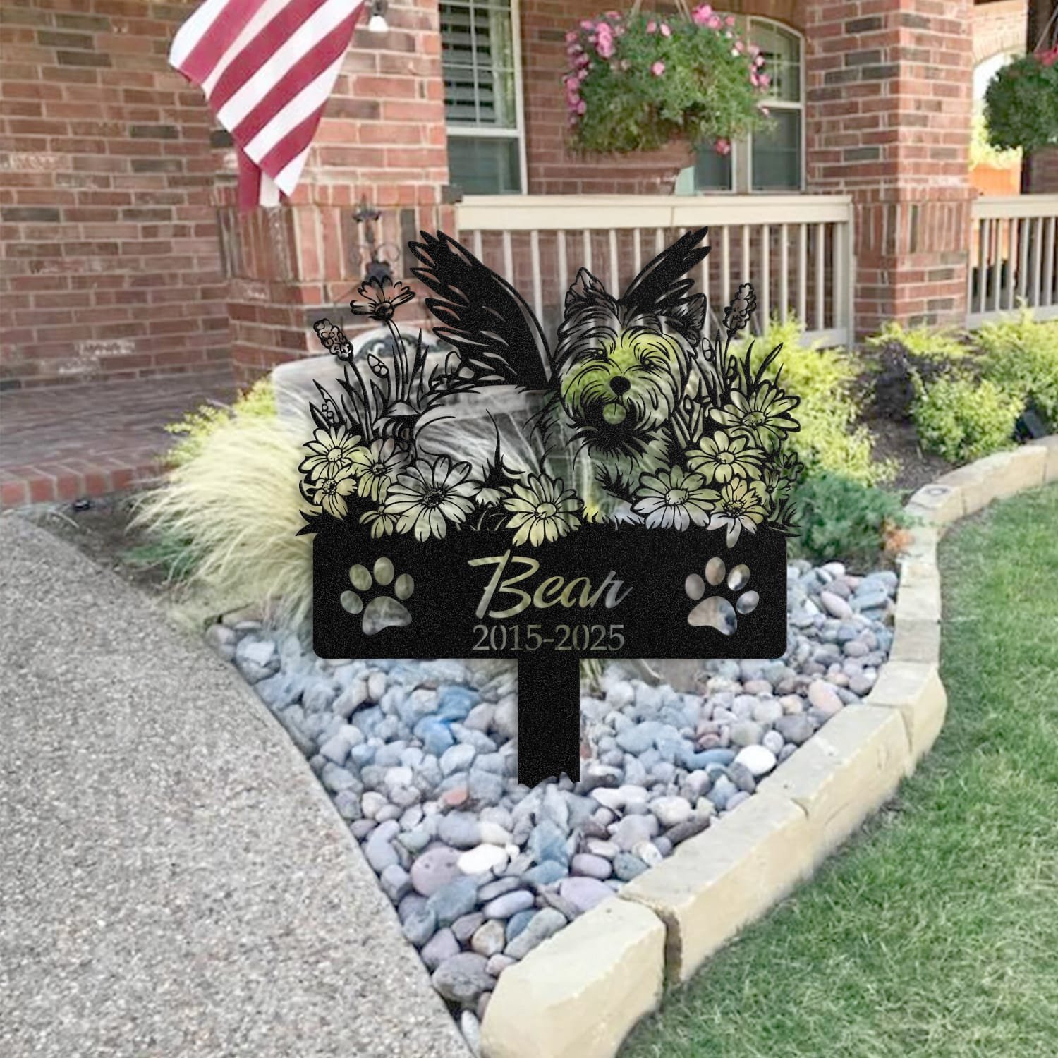 West Highland White Terrier pet grave marker staged near a home entryway, showing the finished angel wings and daisy floral design and name plate outdoors.